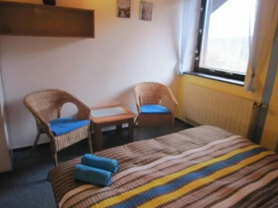 Zimmerbeispiel von Dueto mit Doppelbett und Sitzbereich