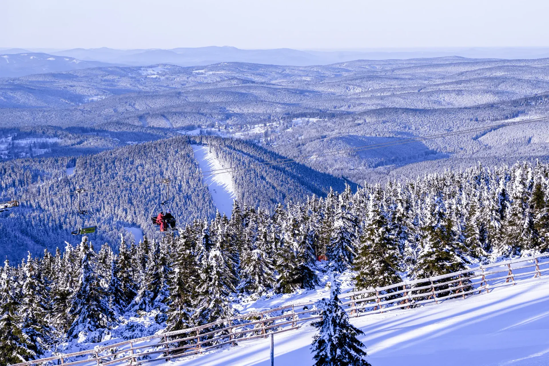Sessellift über einem verschneiten Wald in Rokytnice